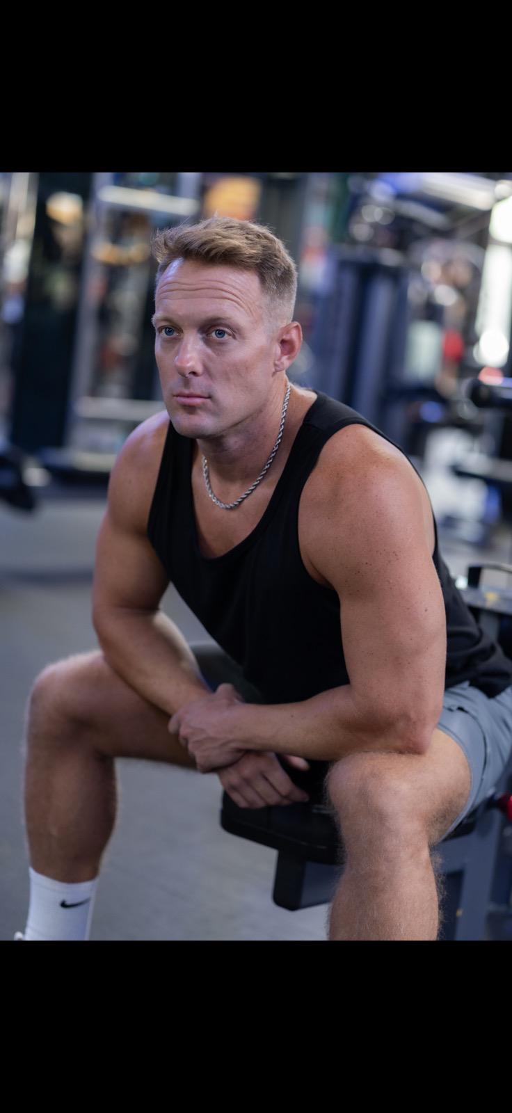 Mike Zdonczik seated on a bench in a commercial gym