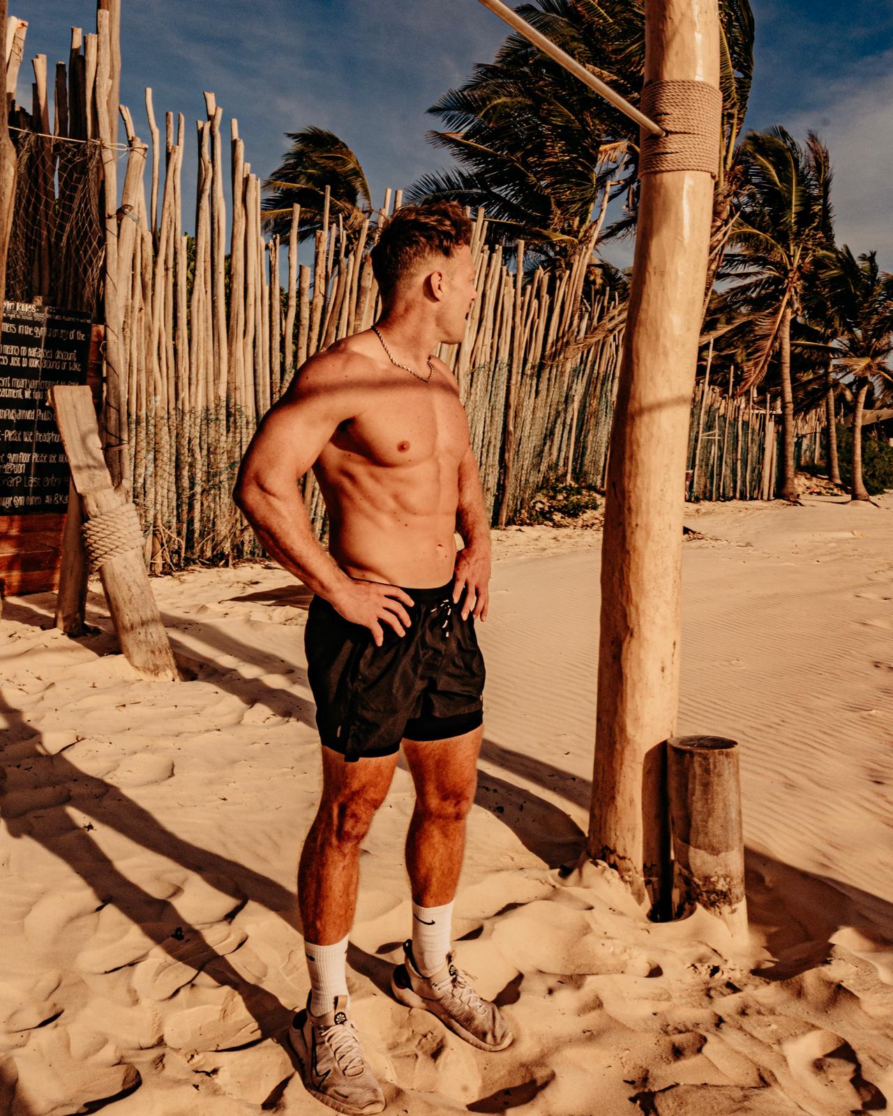 Mike Zdonczik in a powerful stance at a beach gym at sunrise