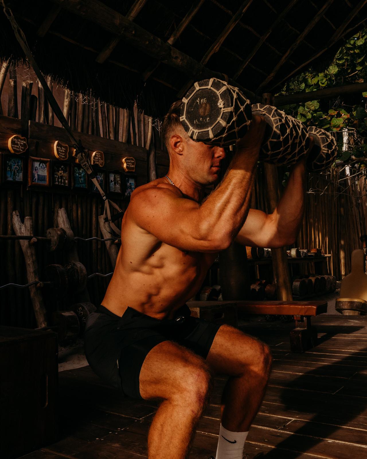 Mike Zdonczik performing a kettlebell squat under a palapa
